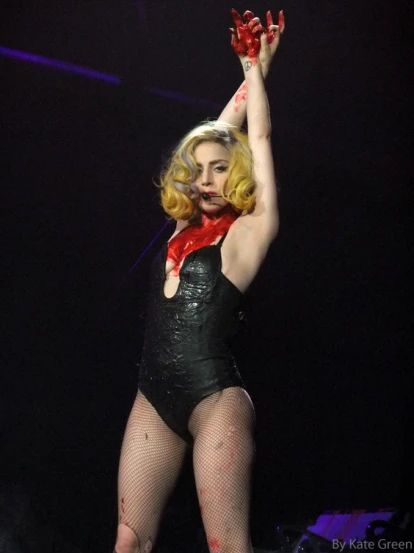 a blond lady with arms outstretched while standing on stage