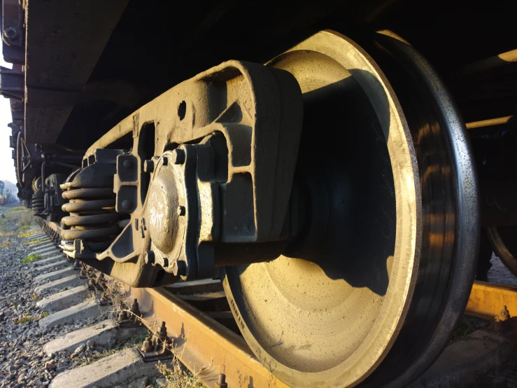 the front wheels of an old train on the tracks