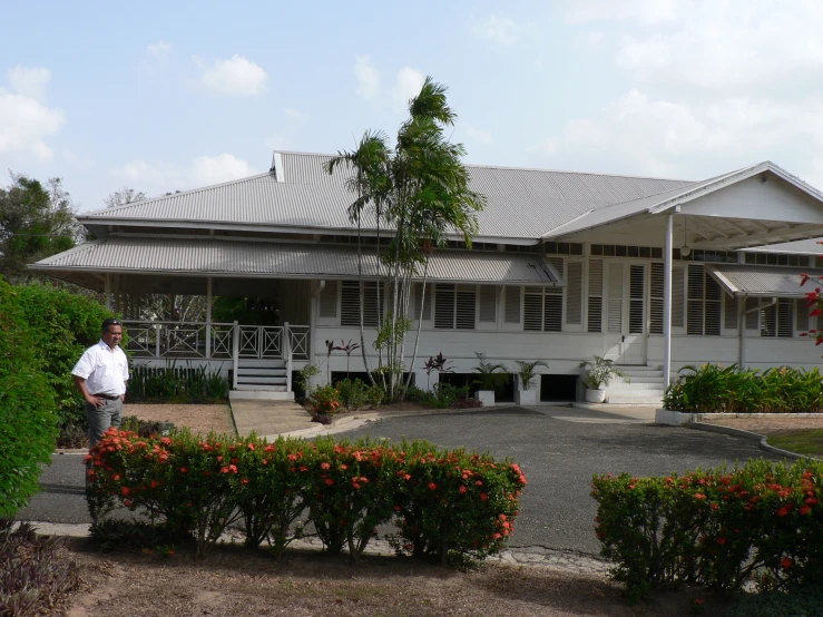 man standing in front of a large house