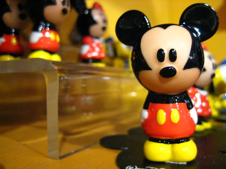 mickey mouse figurines are shown next to a shelf