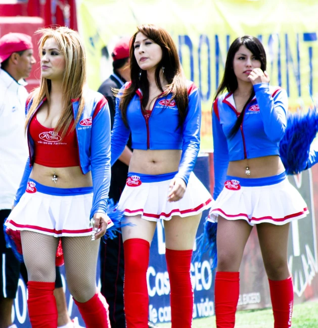 a group of women in cheerleader outfits, both wearing red and white