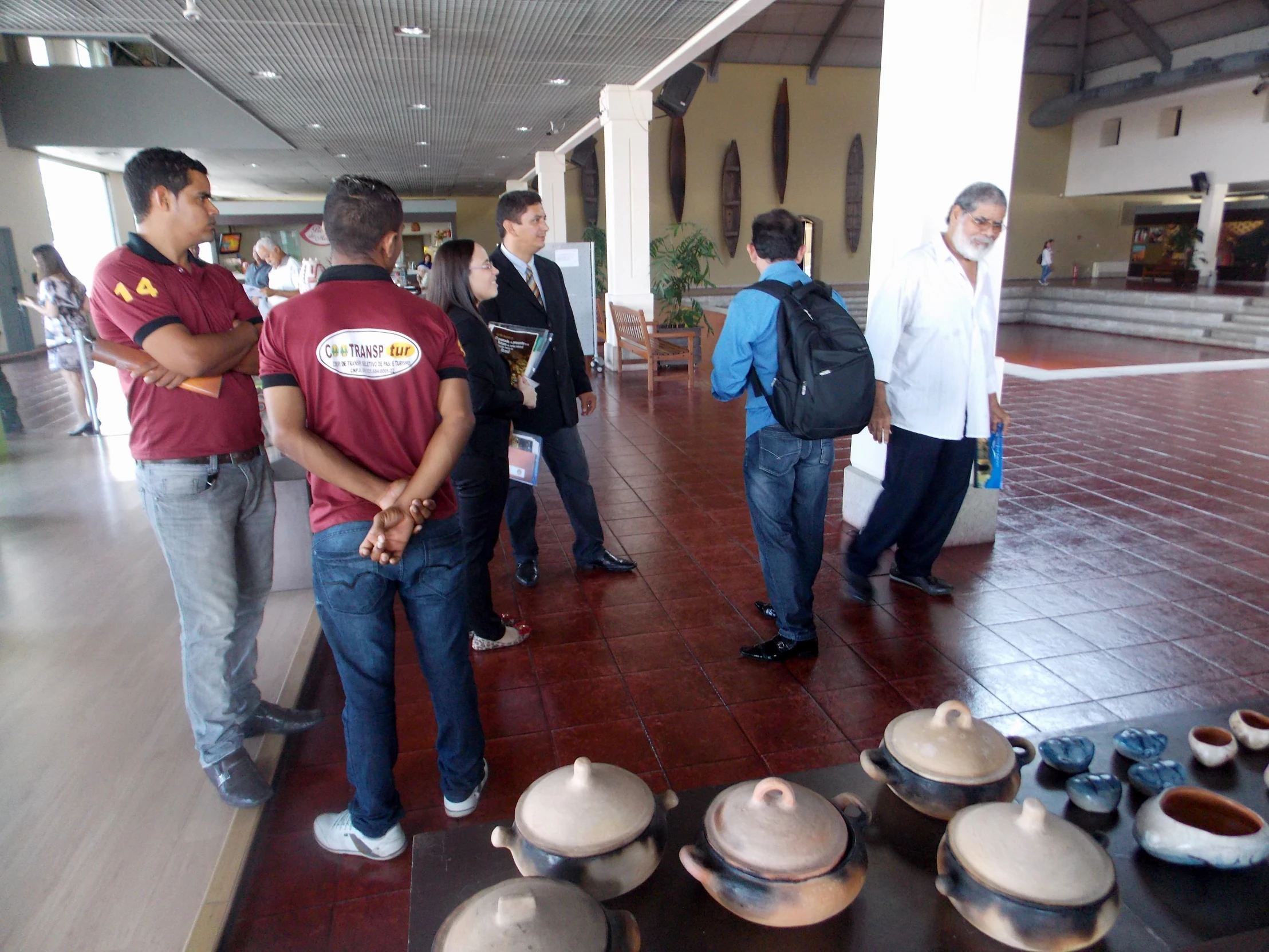 a group of people are standing around looking at pots