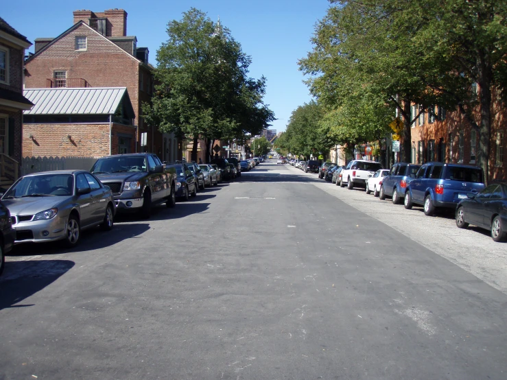 a row of parked cars sitting along the side of a street