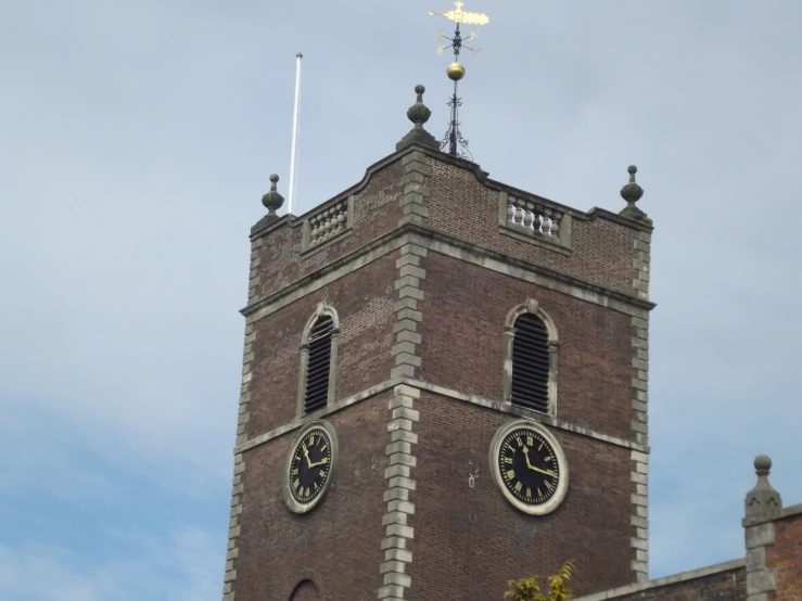 a very tall brick building with two clocks on it's sides