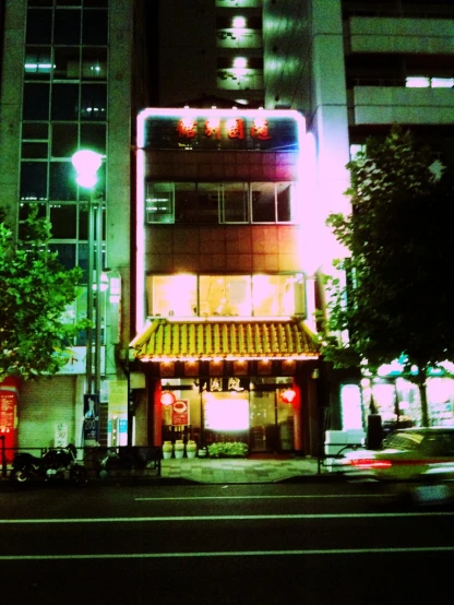 a building with lights around it and trees on the side