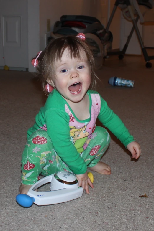 a baby girl is playing on the ground with her toy