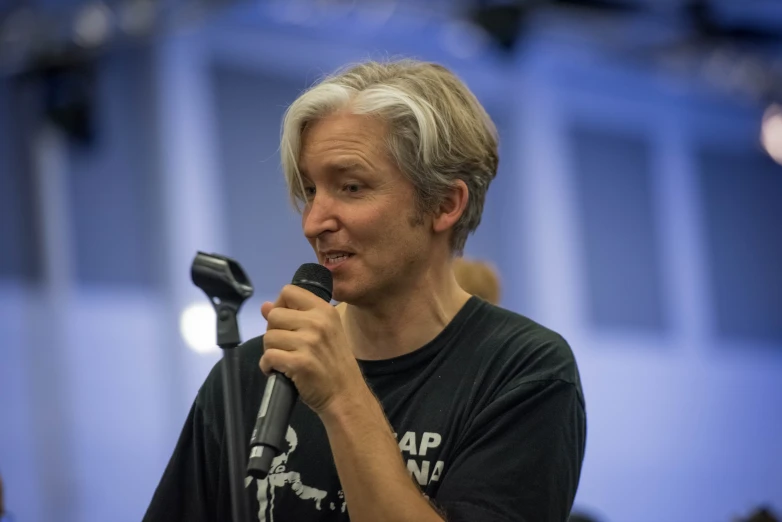 a woman is holding a microphone and speaking