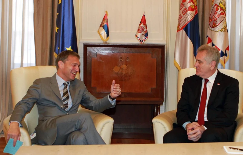 two men sitting in chairs and gesturing