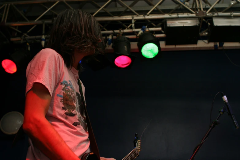 a person that is playing guitar by some lights