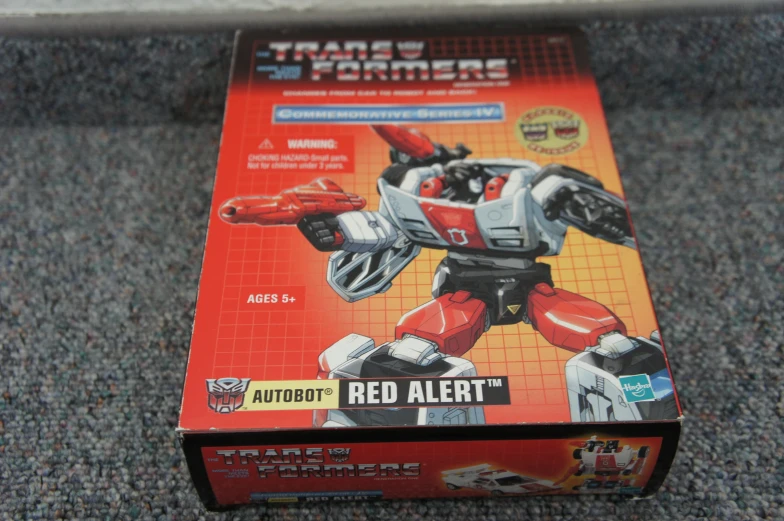 a red toy from the series titans box on a gray floor