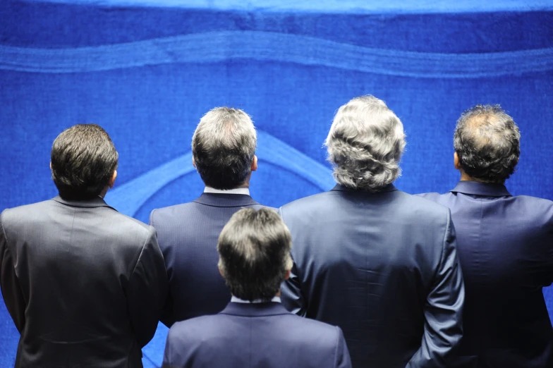 a group of men standing around in front of a wall