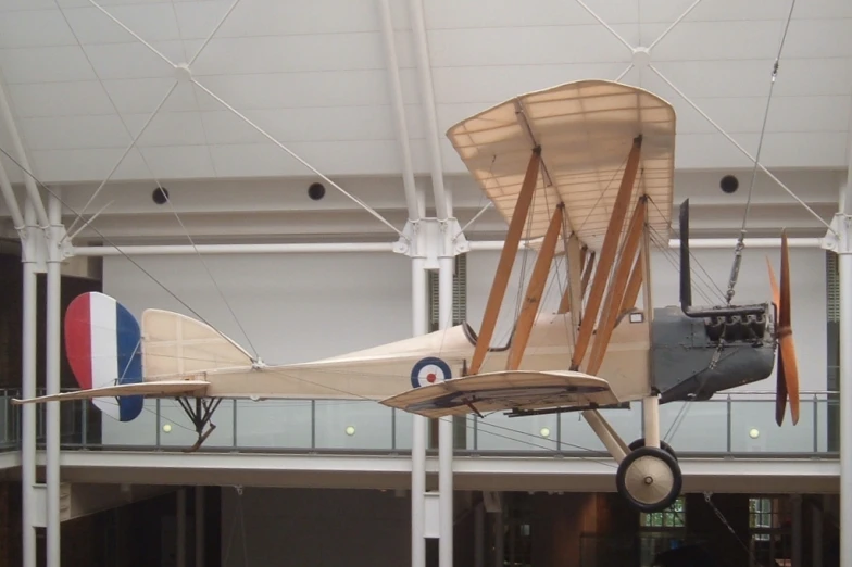 antique model airplane on display in building with flags