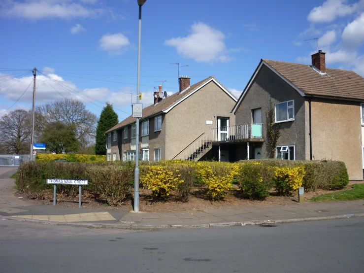 an apartment complex with a street light and shrubbery