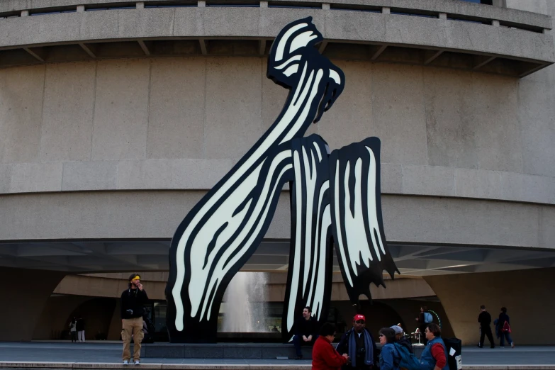 large statue with art work in front of building