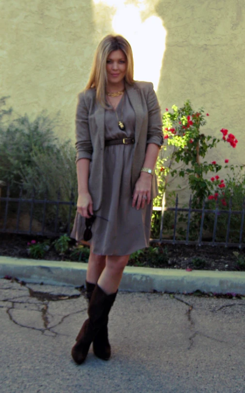 woman in brown dress and black boots standing in driveway