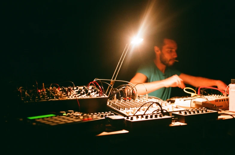 a man is mixing on a mixer in the dark