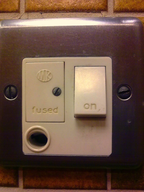 a close up view of the light switch on a tile wall