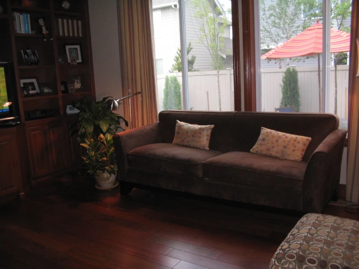 a living room with large windows and a brown couch