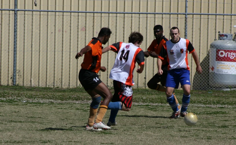 the man is playing soccer outside on the field