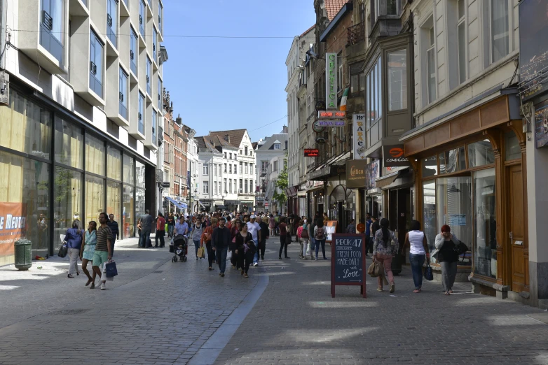 an image of a crowded sidewalk that is in a shopping district