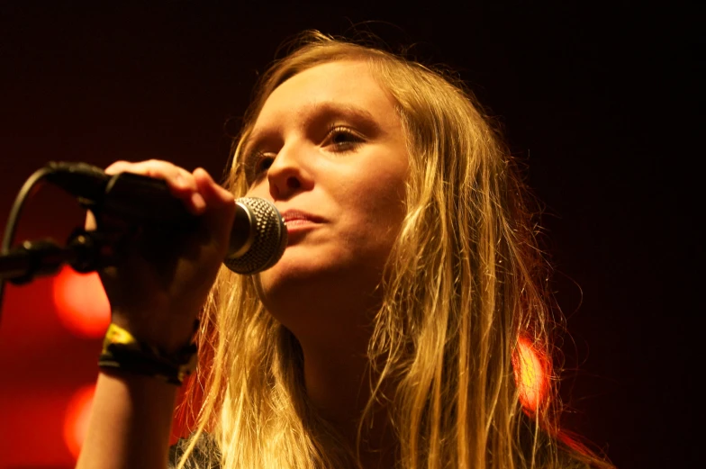 a woman singing into a microphone on stage