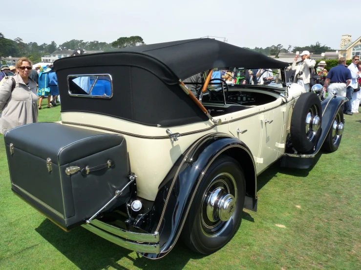 a antique car parked on the grass at a car show