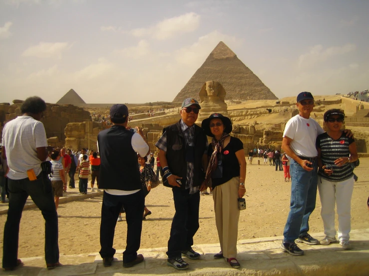 a group of people standing in front of the pyramids