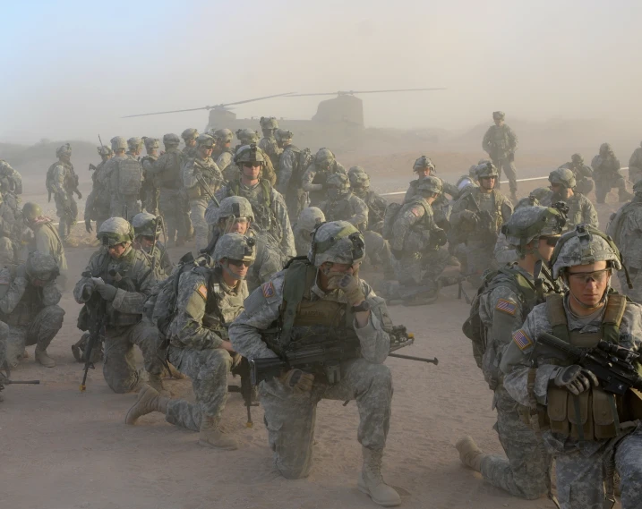 soldiers marching on sand with guns in their hands