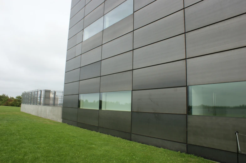 side of a large gray building with many windows