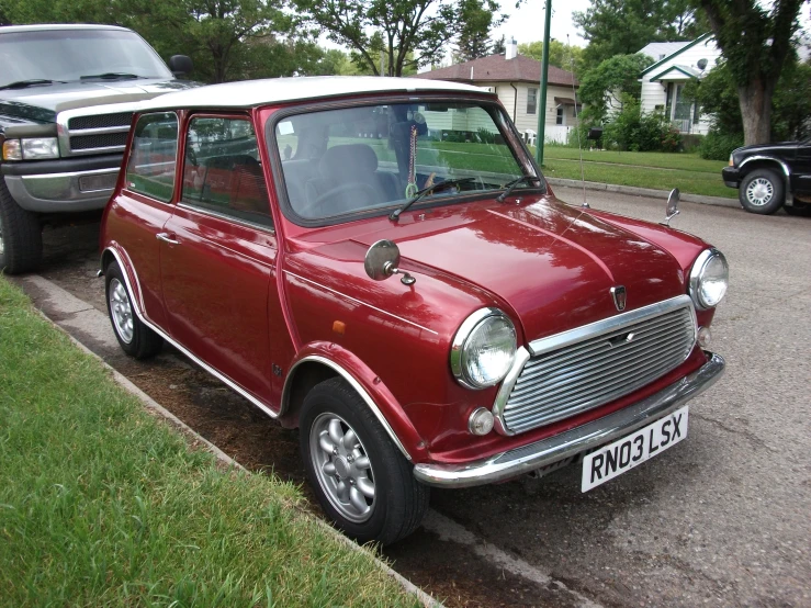 an old maroon car is parked by a house