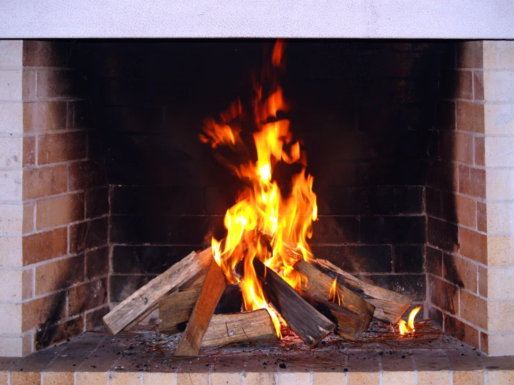 a fire burns in a fireplace with lots of logs