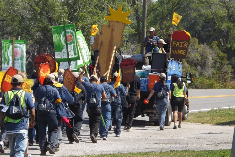 a group of people carrying wooden signs down a street