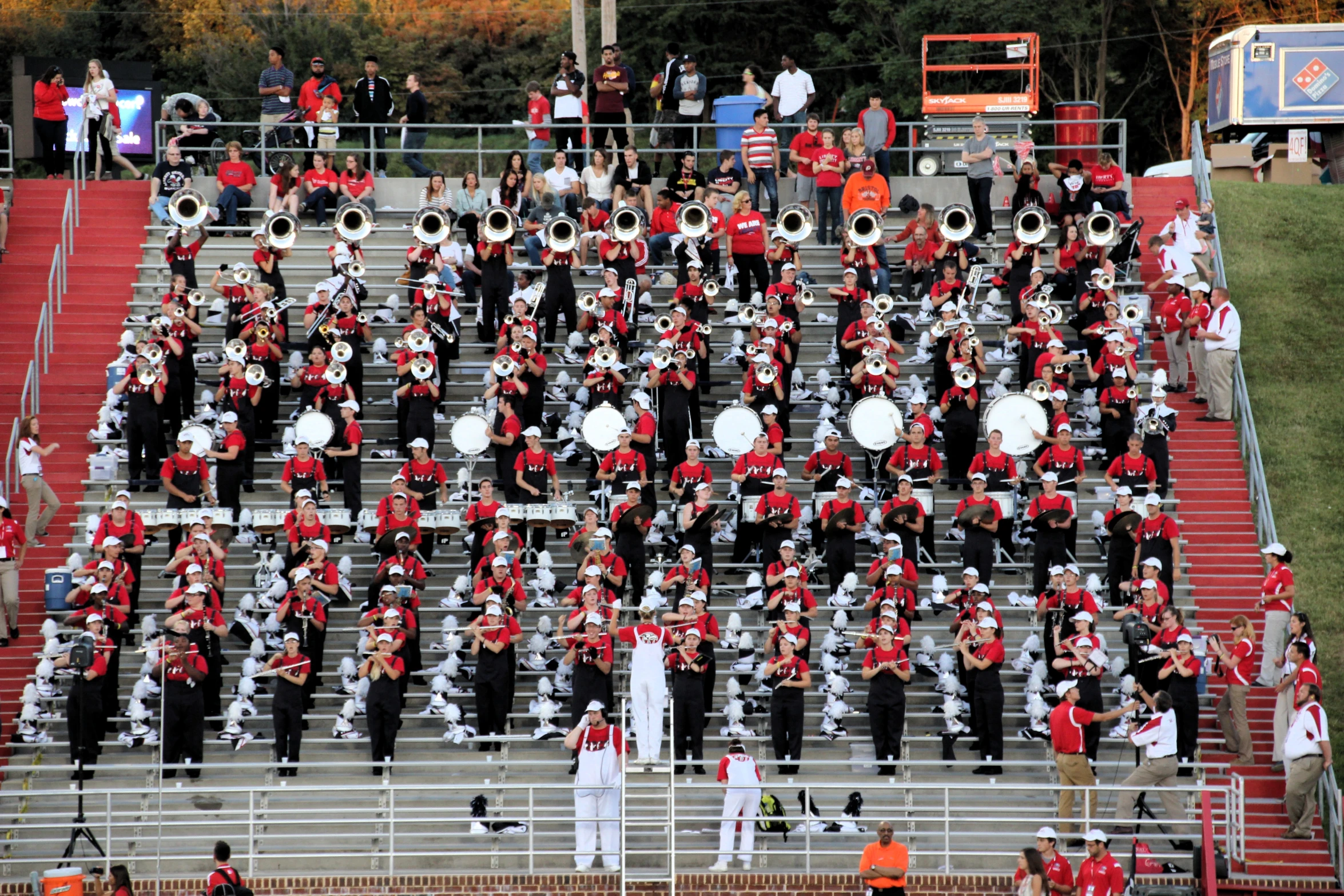 a marching band on a football field with people watching from the bleachers