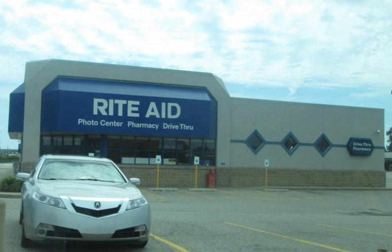 a car parked in front of a building with a for rent sign