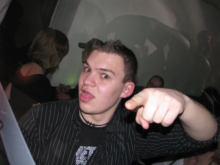 a man pointing with both hands and wearing striped shirt