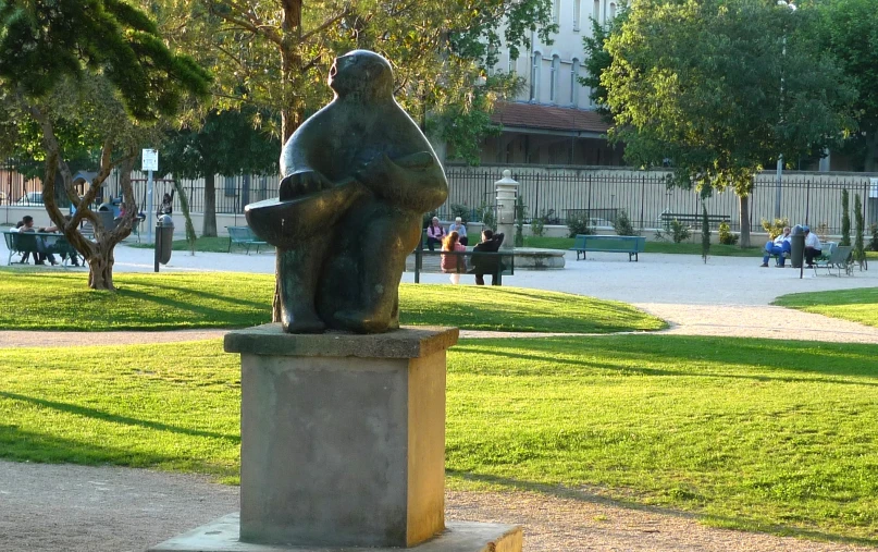 statue of seated man sitting on a block in a public park
