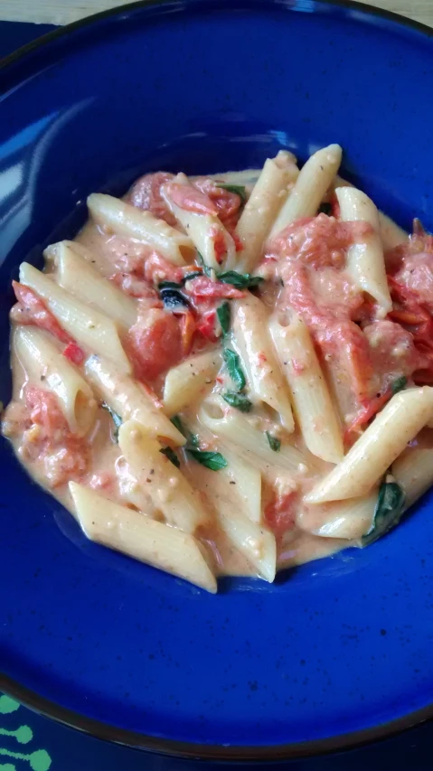 a close up of a plate of pasta with tomatoes