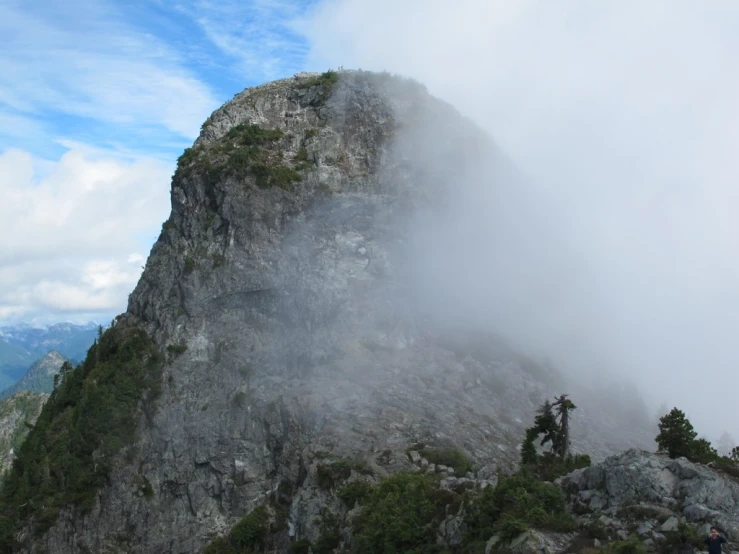 a mountain with a foggy cloud covering the summit