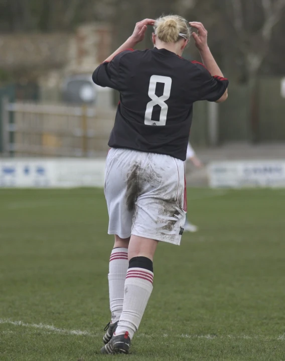 the boy is in uniform and holding his hands up