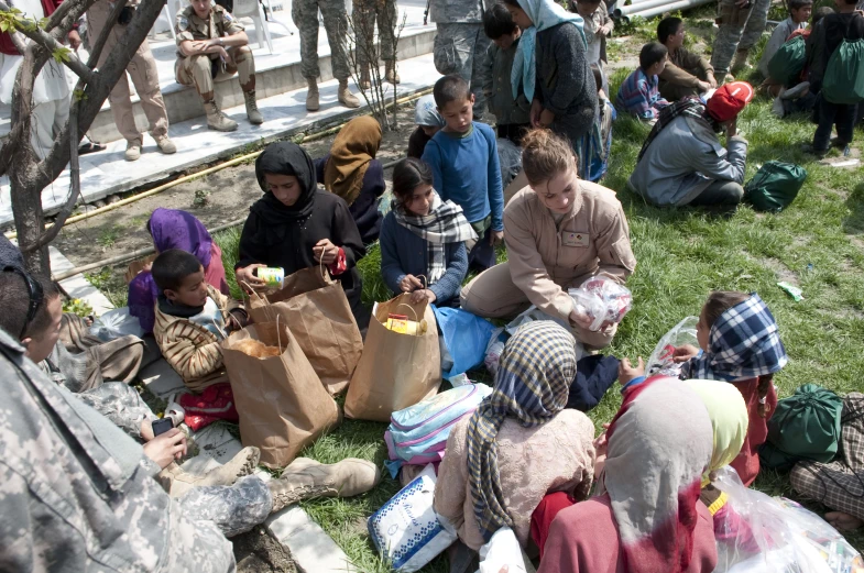 people sitting in the grass eating on a sunny day