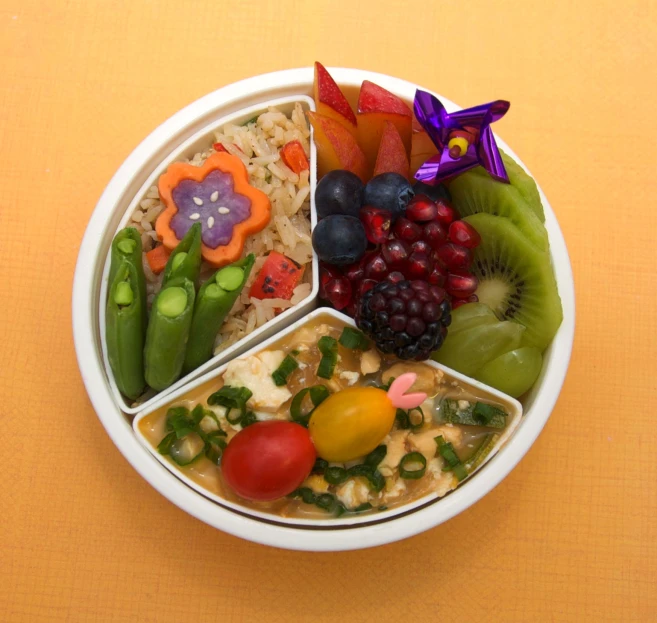 a bowl has several sections with fruits and vegetables in them