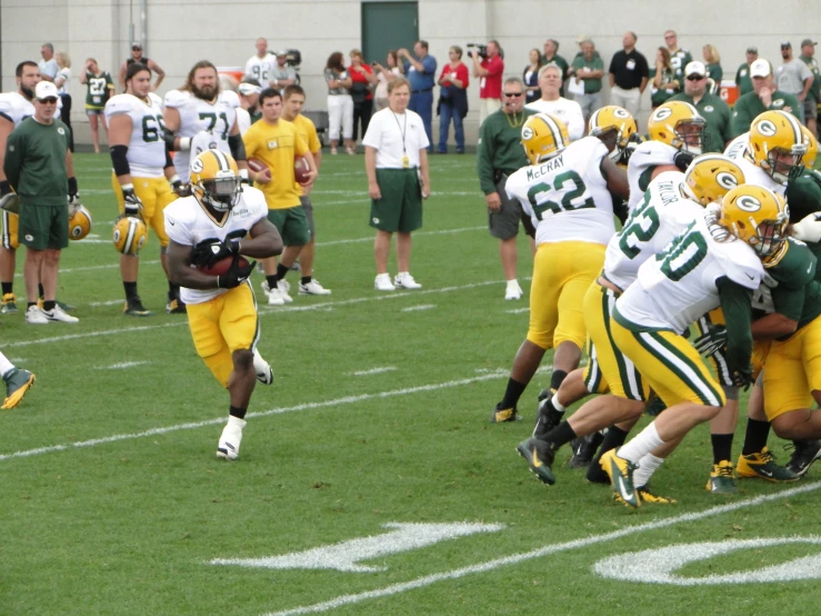 a football game with a bunch of players running and playing