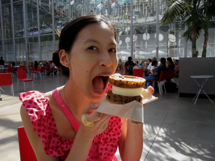 a girl in a pink dress eating food