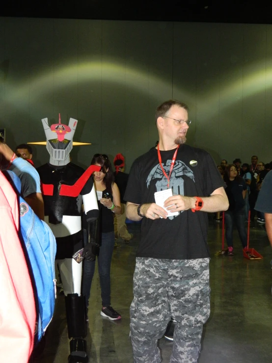 man in camo pants talking to woman in darth vader mask