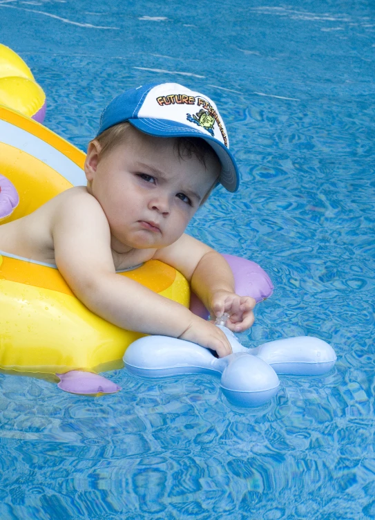 a young child wearing an inflatable float in a swimming pool