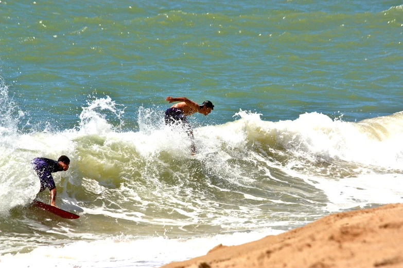 two people surf on waves in the ocean