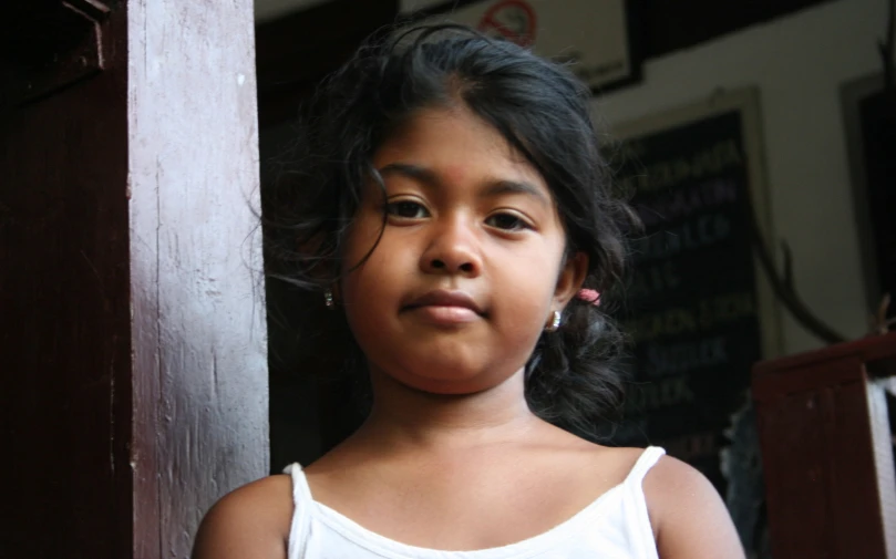 a little girl with an odd look standing outside