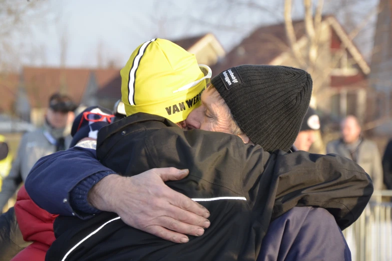 two people that are hugging each other in a street