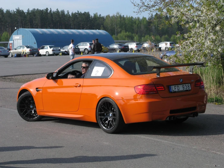 an orange car sitting on top of a parking lot