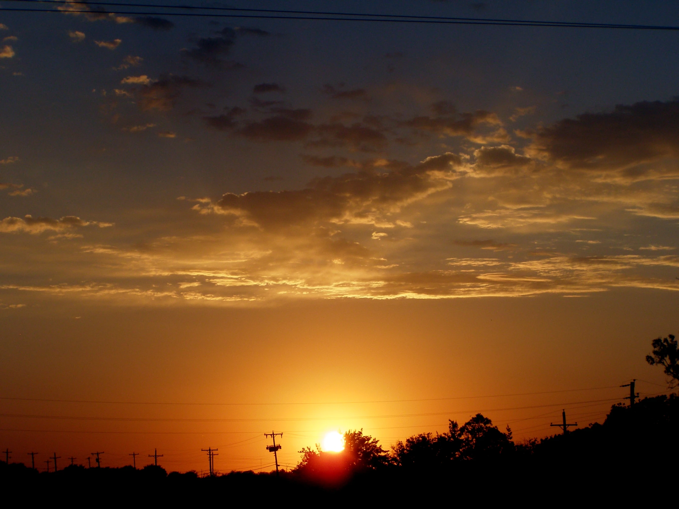 a dark sky that has a sunset in it